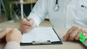 Médico anotando en la historia clínica de un paciente durante una consulta